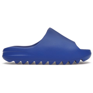 Las Yeezy Slide Azure son sandalias de color azul real, con diseño slip-on y suela dentada de goma, ideales para la primavera y verano.