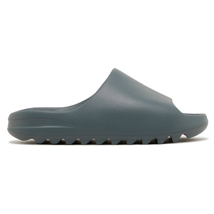 Las Yeezy Slide Slate Marine son sandalias slip-on en tono gris azulado, con suela dentada y diseño en espuma EVA, ofreciendo comodidad y tracción.